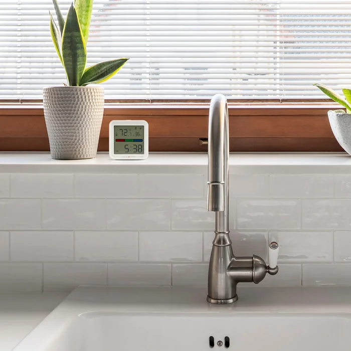 AcuRite temperature and humidity monitor on a kitchen windowsill